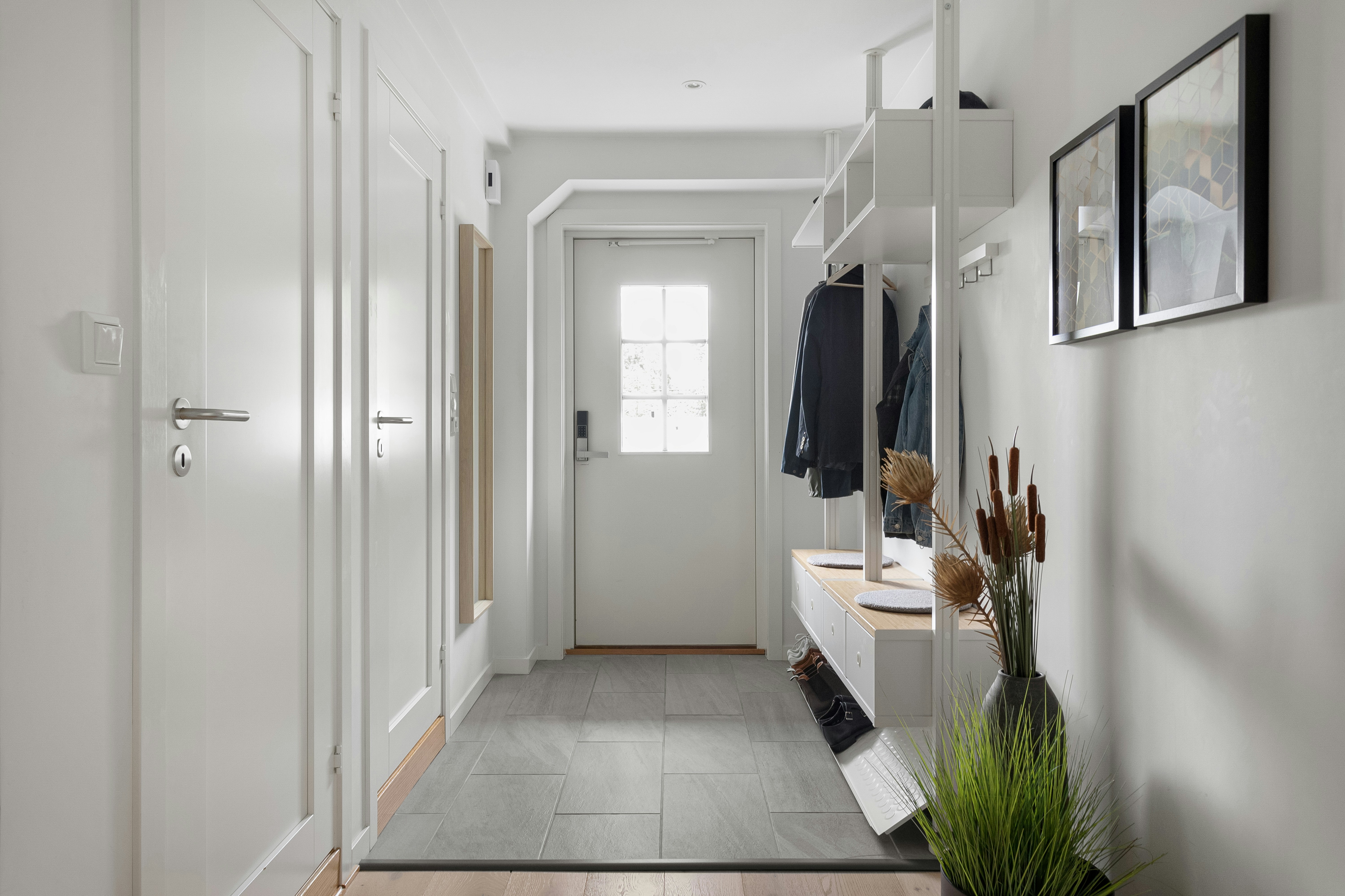 A hallway with a white wall and wooden floors